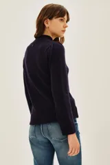 Sweater de punto color azul marino, con cuello alto y detalle de botones decorativos en el hombro. Presenta mangas largas con puños acanalados y un ligero fruncido en la parte superior de la manga.