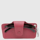 Estuche para lentes de cuero sintético con textura granulada, color bordó, con cierre de solapa a presión y gancho metálico lateral para colgar.