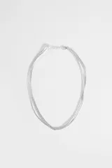 Collar de tres hileras compuesto por pequeñas cuentas metálicas cilíndricas en color plateado, con cierre de mosquetón y cadena de alargue.