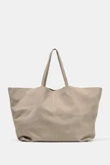 Bolso tipo maxi shopper confeccionado en serraje, con diseño minimalista y doble asa de hombro. Cuenta con un compartimento principal amplio y un bolsillo interior con cierre.