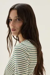 Remera de manga larga a rayas horizontales marrones y blancas, con cuello redondo y corte holgado.