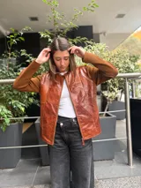 Campera con cuerpo delantero de cuero en diseño de parches y mangas de lana merino. Presenta cuello redondo, cierre frontal y corte recto.