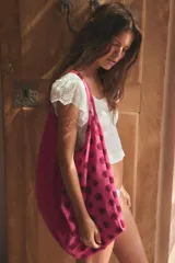 Maxi bolsa combinada de algodón con diseño de lunares en tonos fucsia y rojo, asas de hombro y cierre con cremallera metálica.