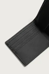 Billetera de diseño compacto con textura granulada, cuenta con compartimento para billetes, ranuras para tarjetas y monedero con cierre a presión.