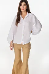 Camisa de lino italiano con estampado a rayas verticales irregulares, de corte holgado, cuello clásico, mangas abullonadas y cierre frontal con botones.