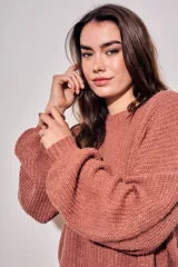 Sweater de tejido bouclé texturado color beige, con cuello redondo y mangas largas holgadas de corte amplio.