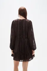 Vestido corto de manga larga con cuello en V y cierre frontal de botones. Presenta un diseño holgado con falda de volado en el ruedo y un estampado sutil de rayas verticales brillantes sobre fondo oscuro.