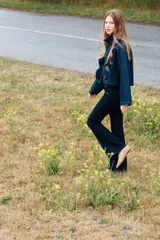 Jeans de denim color azul oscuro, tiro bajo, corte ajustado en muslos y acampanado desde la rodilla. Presenta cierre y botón frontal, bolsillos abiertos delanteros y bolsillos traseros con solapa y botón.