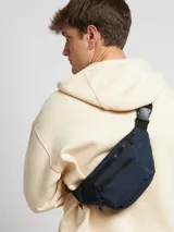 Riñonera negra con dos compartimentos con cierre y correa ajustable.