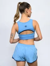 Top deportivo de Umbro para mujer, color azul marino, con el escudo del Club Nacional de Football en el centro y banda elástica inferior con la marca estampada.