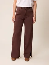 Pantalón jean de tiro alto y corte recto, color marrón chocolate, con aberturas laterales en el ruedo.