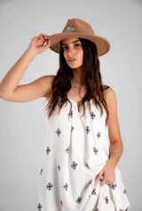 Vestido blanco con estampado de cruces negras, sin mangas y corte holgado.