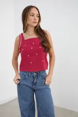 Top bordeaux de escote recto y tirantes anchos con aplicación de tachas doradas.