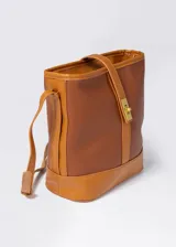 Bolso tipo tote de cuero sintético color marrón, con doble asa corta para llevar al hombro. Tiene un compartimento principal con cierre y un bolsillo interno.