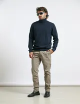 Polera de tejido de punto fino en color verde oliva, con cuello alto acanalado y mangas largas.