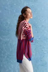 Sweater de tejido jacquard con diseño de rayas verticales en tonos rojo, blanco y azul. Presenta cuello redondo, hombros caídos y puños en contraste de color azul.
