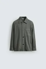 Sobrecamisa de hombre, color verde militar, con cuello solapa, manga larga y cierre frontal de botonadura. Presenta un bolsillo de plastrón en el pecho y bolsillos laterales en la cadera. El tejido tiene un efecto lavado.