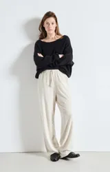 Sweater de punto de corte amplio y holgado, con cuello barco y mangas largas. Presenta una textura esponjosa y un diseño minimalista.