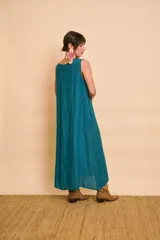 Vestido largo color verde petróleo con escote en V, detalles de bordado metálico en el escote y bolsillos laterales.