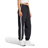Pantalón Adidas Essentials French Terry Cuffed 3 Tiras de mujer, color negro, confeccionado en tejido de felpa francesa. Cuenta con cintura elástica con cordón ajustable, puños elastizados en los tobillos y las tres tiras características de la marca en los laterales.