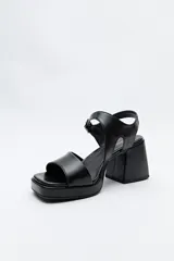 Sandalias plateadas con plataforma fina y taco ancho forrado. Incorporan pulsera con hebilla metálica y capellada ancha.