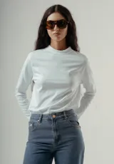 Camiseta de manga larga, cuello redondo, con rayas horizontales marrones sobre fondo blanco. Presenta un pequeño logo bordado en rojo en el pecho.