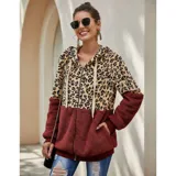 Campera tipo polar con cierre frontal, diseño combinado con estampado animal print en la parte superior y tejido de peluche blanco en la parte inferior. Cuenta con capucha con cordones ajustables y dos bolsillos frontales.