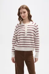 Sweater de punto a rayas horizontales en tonos marrón y blanco, con cuello redondo y cierre frontal parcial con botones. Presenta un diseño holgado de manga larga con puños y ruedo acanalados.