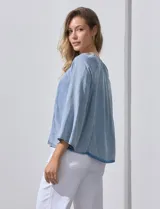 Blusa celeste de lyocell con cuello a la base y escote en V con lazo de ajuste. Manga larga amplia.