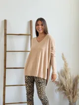 Sweater beige de tejido de punto, con escote en V, corte oversize y tajos laterales.