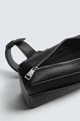 Bandolera negra de formato vertical con textura, diseño geométrico y correa ajustable para llevar al hombro.