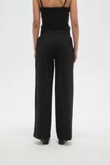 Pantalon de vestir de corte recto y tiro alto, confeccionado en tela de viscosa con diseño de rayas verticales finas en color blanco sobre fondo negro.