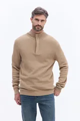 Buzo de tejido acanalado color beige, con cuello alto y cierre frontal parcial. Presenta puños y ruedo acanalados para un ajuste cómodo.