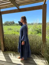 Vestido largo color verde oliva, de lino, con corte amplio, cuello mao, escote en V y mangas largas acampanadas.