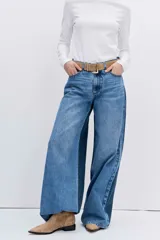 Jean de corte wide leg en color azul medio, con diseño de tiro alto y cierre frontal con botón y cremallera.