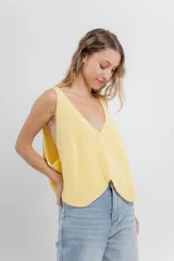 Chaleco celeste de punto con escote en V y cierre frontal con botones. Tejido calado y corte holgado.