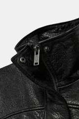 Cazadora de corte oversize confeccionada en 100% piel. Presenta cuello subido, manga larga con hombro caído y cierre frontal mediante cremallera y botones a presión ocultos bajo una solapa. Incluye bolsillos laterales ocultos en las costuras y forro interior.