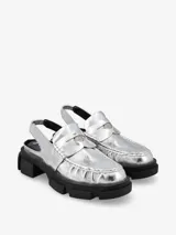 Mocasín mule de cuero negro con hebilla metálica y suela track.