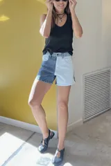 Short de jean de tiro alto con diseño color block, una pierna en denim azul y la otra en denim blanco.