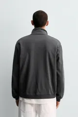 Sudadera de algodón ligero en color rojo, con cuello subido y cierre frontal de cremallera. Presenta mangas largas con puños acanalados y dobladillo inferior en rib.