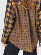 Camisa de manga larga con diseño estampado de rombos en tonos tierra, confeccionada en viscosa. Presenta cuello clásico, cierre frontal con botones, un bolsillo cuadrado en el pecho con logo bordado y puños a juego.