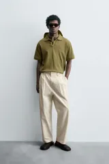 Polo de manga corta color verde oliva, con cuello solapa y abertura frontal tipo polo. Presenta una textura acanalada vertical y un calce regular.