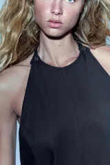 Mono largo de lyocell color negro, con cuello halter, cierre lateral con cremallera oculta y botones en el cuello. Presenta un diseño holgado con bajo acabado en puño elástico.