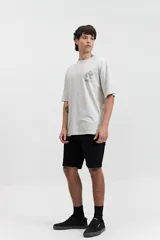 Remera oversize de algodón con efecto acid wash, color blanco hueso. Estampado grande en la espalda con un diseño circular que incluye una serpiente enroscada, texto "MISTRAL REG", "LOS ANGELES", "CALIFORNIA", "VINTAGE DENIM", "REGISTERED" y "TM 76".