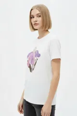 Remera de manga corta color azul marino con cuello redondo y estampado frontal de una flor en tonos celestes y blancos.