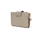 Billetera tipo fichero color beige, confeccionada en material textil con cierre de solapa y broche magnético. Incluye una correa de muñeca extraíble y un aplique circular con el logo de la marca en el frente.