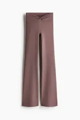 Leggings de yoga acampanados de tiro alto en tejido funcional, con cintura ancha y detalle de nudo en el frente.