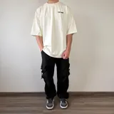 Pantalón cargo tipo parachute de color beige, con calce baggy, bolsillos laterales con solapa y cordones ajustables en los tobillos.