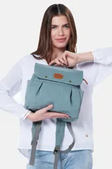 Mochila de lona estilo vintage con solapa frontal, bolsillos laterales y correas ajustables. Presenta detalles en cuero sintético y un parche decorativo en la parte superior.