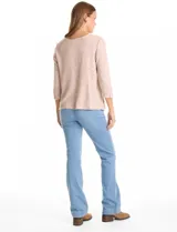 Buzo de tejido soft color beige con textura jaspeada, cuello redondo, mangas tres cuartos con detalle de botones en los puños y tajos laterales en el ruedo.